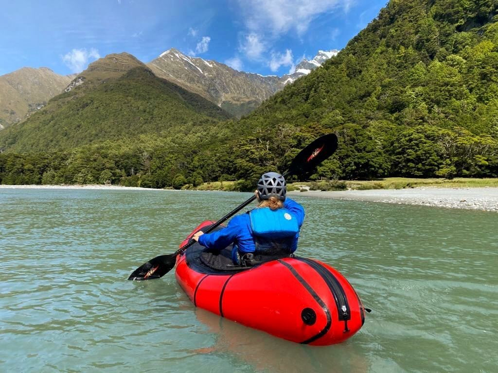 Red packraft with the Shred Carbon paddling in the mountains 