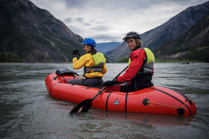 two people paddle a tandem packraft