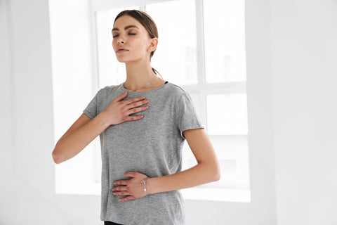 Frau atmet bewusst in den Bauch