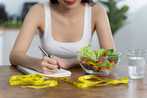 Frau schreibt ein Ernährungstagebuch