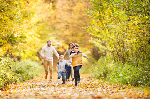 Familie läuft durch den herbstlichen Wald