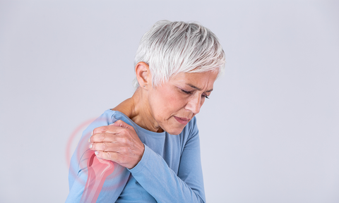 Gelenkschmerzen: Eine Frau hält sich die schmerzende Schulter