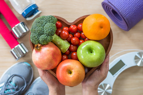 Schale mit Obst und Gemüse, Waage und Sportgeräte