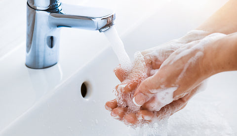 Hände unter dem Wasserhahn