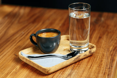 Tablett mit Kaffeetasse und Wasserglas