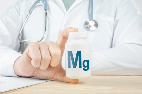 Arzt hält Dose mit Aufschrift Mg in der Hand