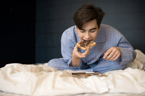 Mann isst im Bett
