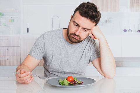 Mann stochert im Salat