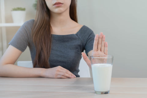 Frau lehnt Glas mit Milch ab
