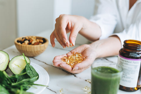 Person hält Omega-3-Kapseln in der Hand