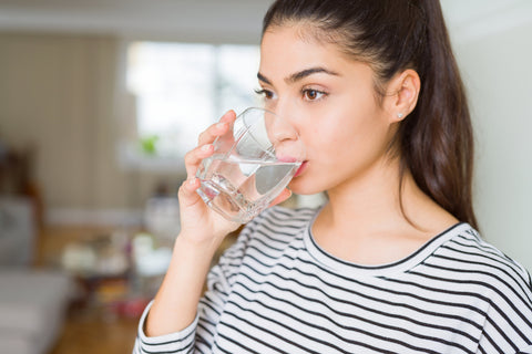 Frau trinkt ein Glas Wasser