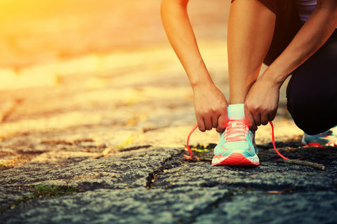 Person schnürt sich die Sportschuhe