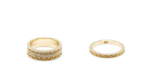 Two Cognac rings side by side. One is 6mm wide with a row of champagne diamonds in the middle and matte metal work on either side.The other is 2mm wide and has matte metal work