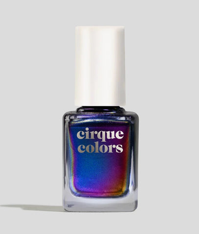 A bottle of nail polish with a white cap. The polish is dupchroms and changes from blue to purple