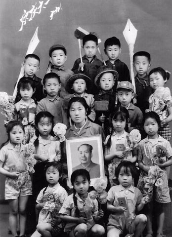 image of children celebrating Children's Day in 1960 with teacher holding a portrait of Mao