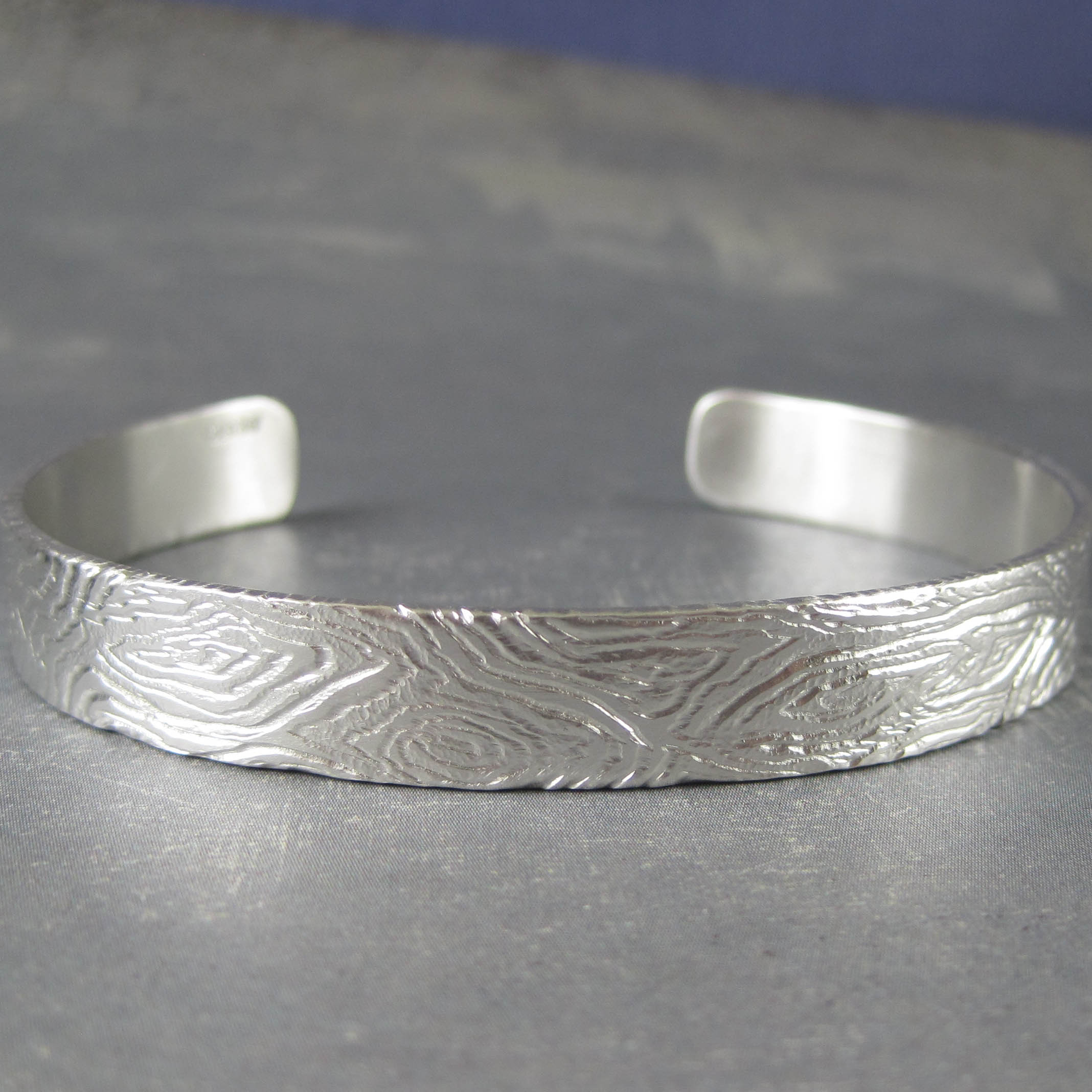 Unique carved sterling silver cuff bracelet with a wood pattern
