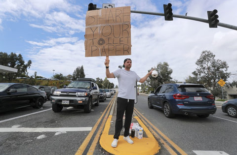 Jonny Blue from Encinitas sets a toilet paper exchange on the street corner