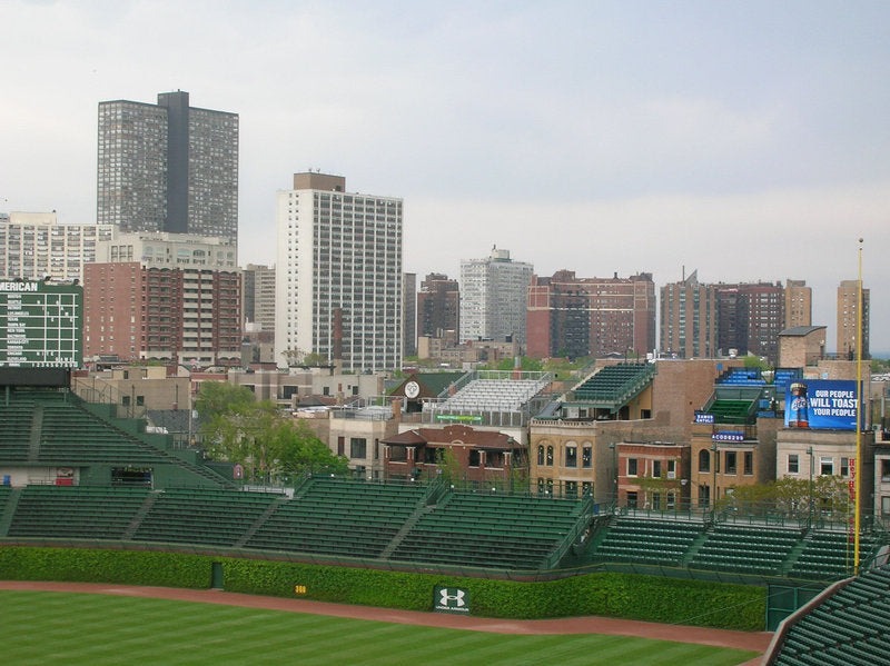 A baseball field with buildings in the background Description automatically generated with low confidence