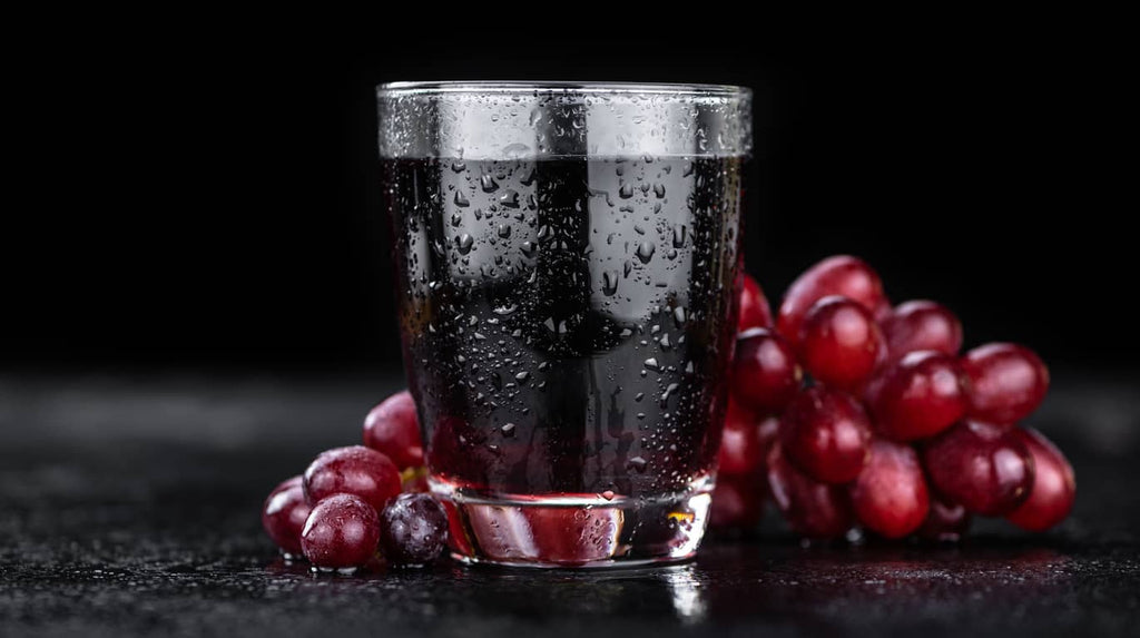 dark glass of grape juice and grapes
