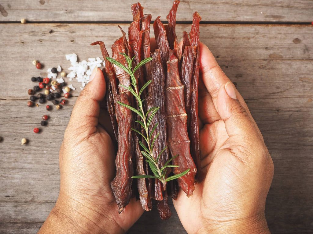 hands holding beef jerky