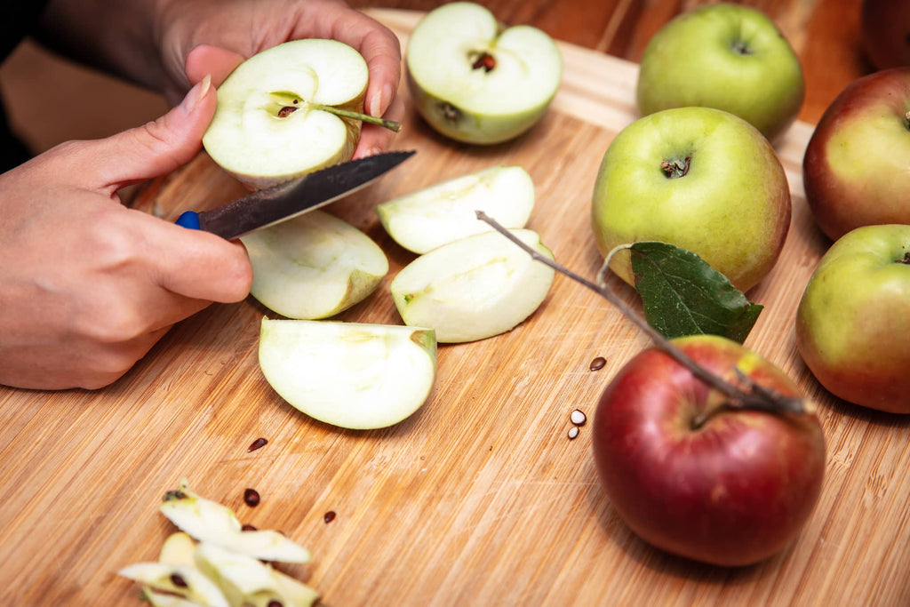hands slicing apples with a knife