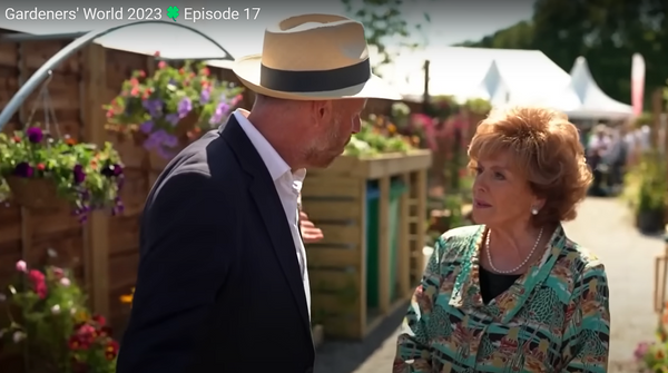 Corrie legend Barbara Know taking a tour of the RHS & MEN Ginnel Garden at the RHS Tatton Park 2023 show, with the Bluum Tripe Wheelie Bin Store with green roof planter in the background