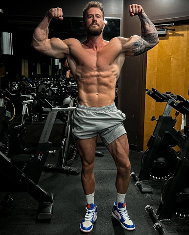 Brenton Ross flexing at a gym to show muscle growth and fat loss after a shred