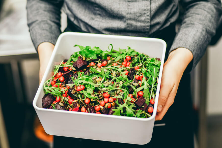 A man holding a dish of salad