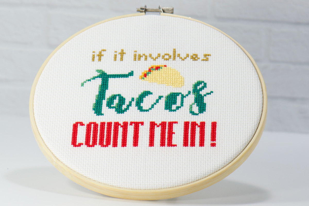 if it involves tacos count me in cross stitch design on white fabric inside wood embroidery hoop