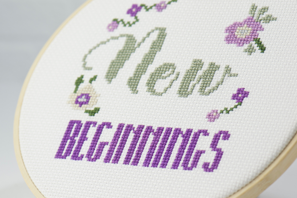 new beginnings words on soft purple, grey, green cross stitch design