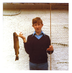 A young man with a large brown trout