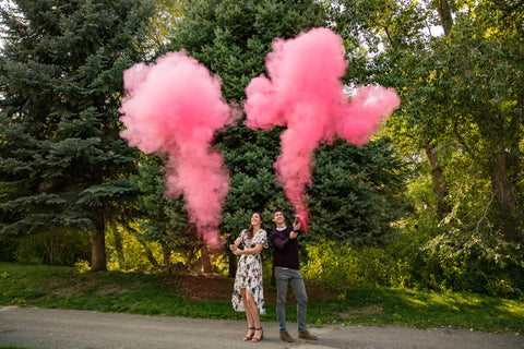 couple finding out the gender of their family using pink powder gender reveal discreet cannons