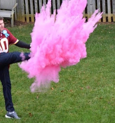 Gender Reveal Football with Pink powder being kicked by Dad