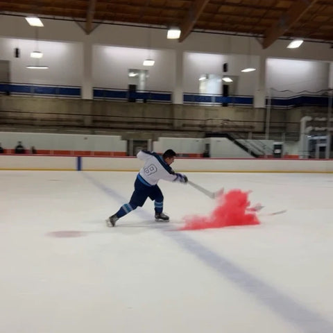 Hockey Puck gender reveal with dad hitting it and pink powder flying out