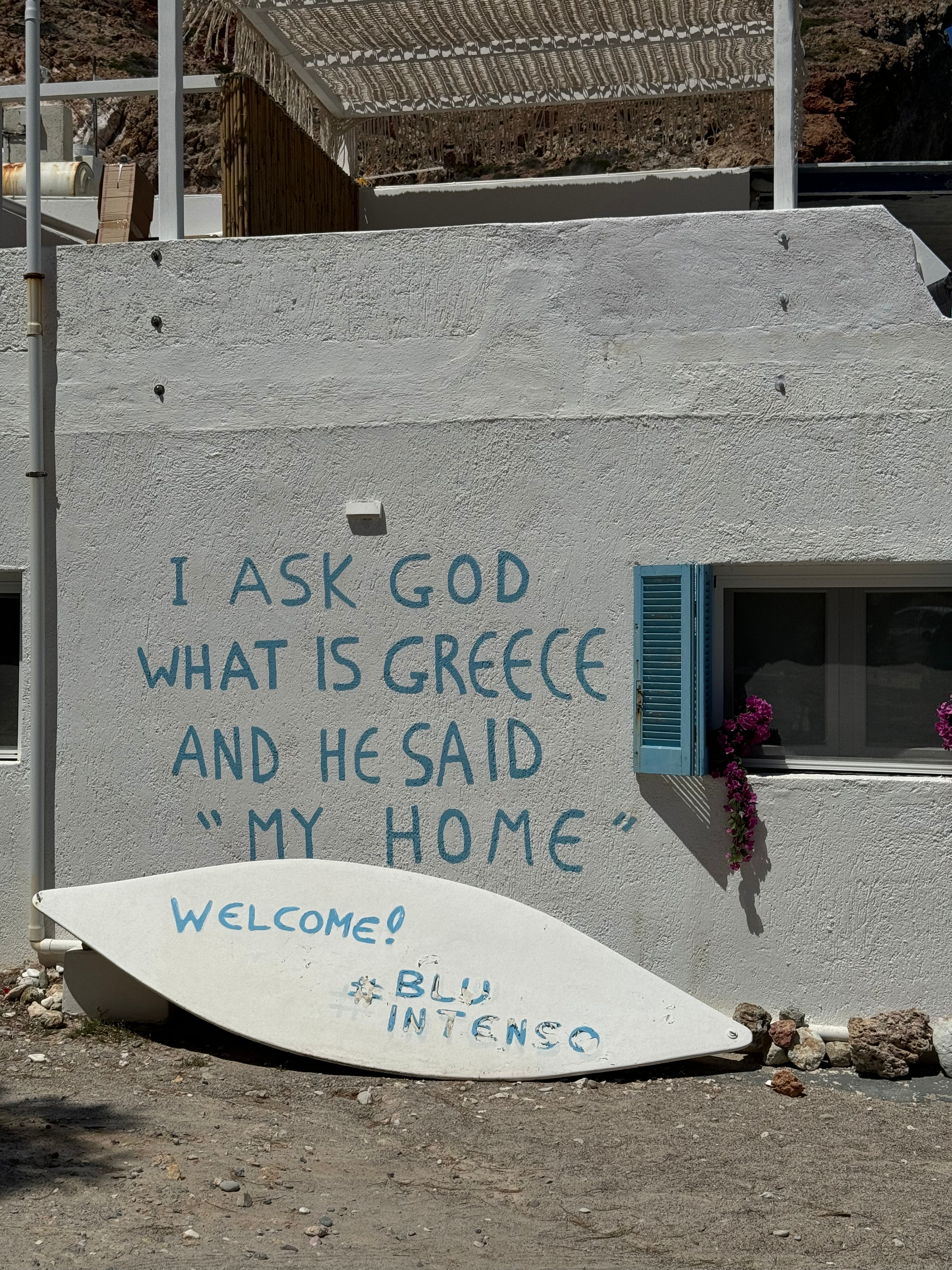 A captivating wall inscription reads 'I asked God where my home is, and he said Greece,' evoking a deep sense of belonging and admiration for the country's beauty.