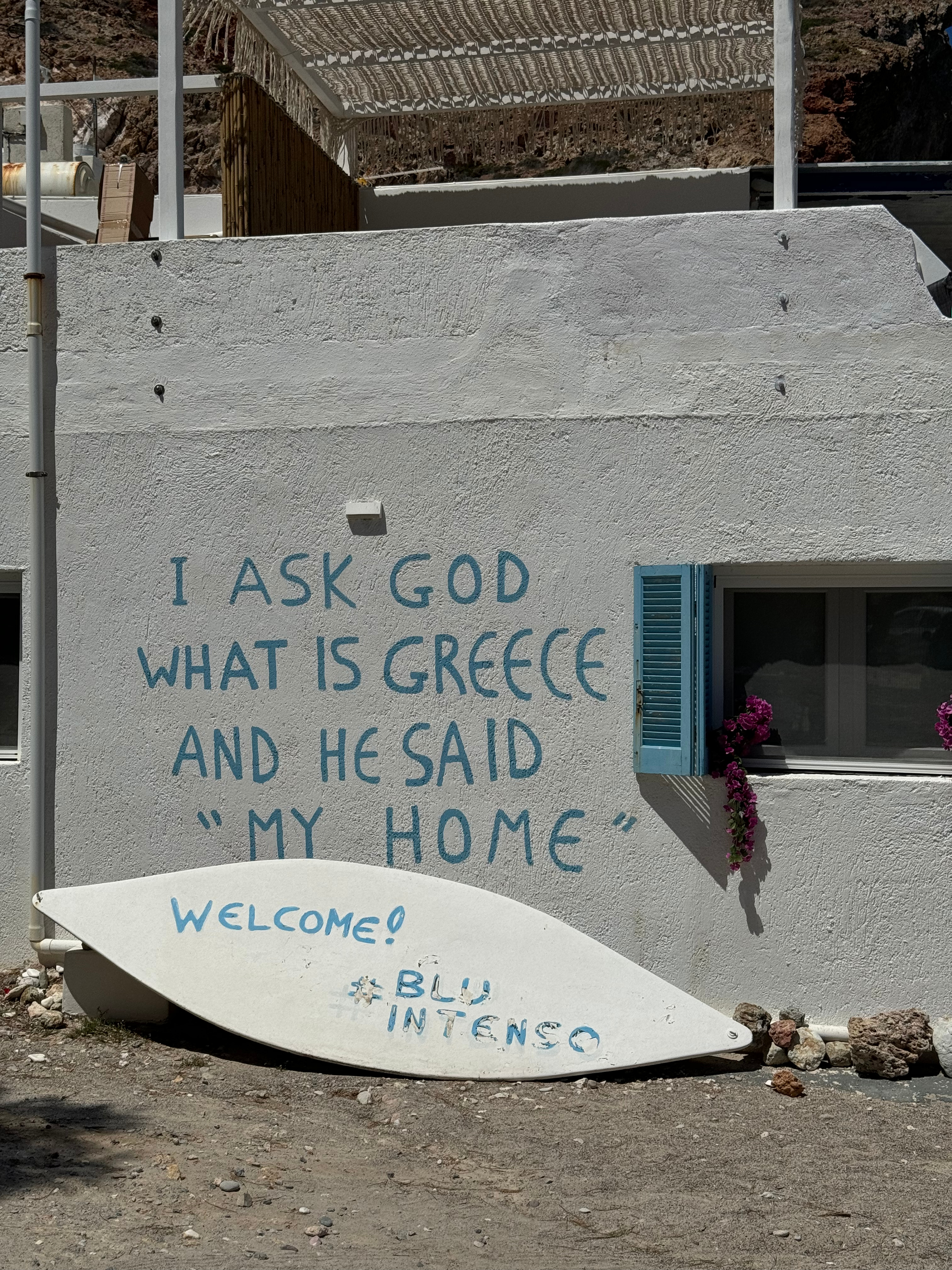 A captivating wall inscription reads 'I ask God where is my home and he says it's Greece,' evoking a sense of belonging and admiration for the country's beauty.