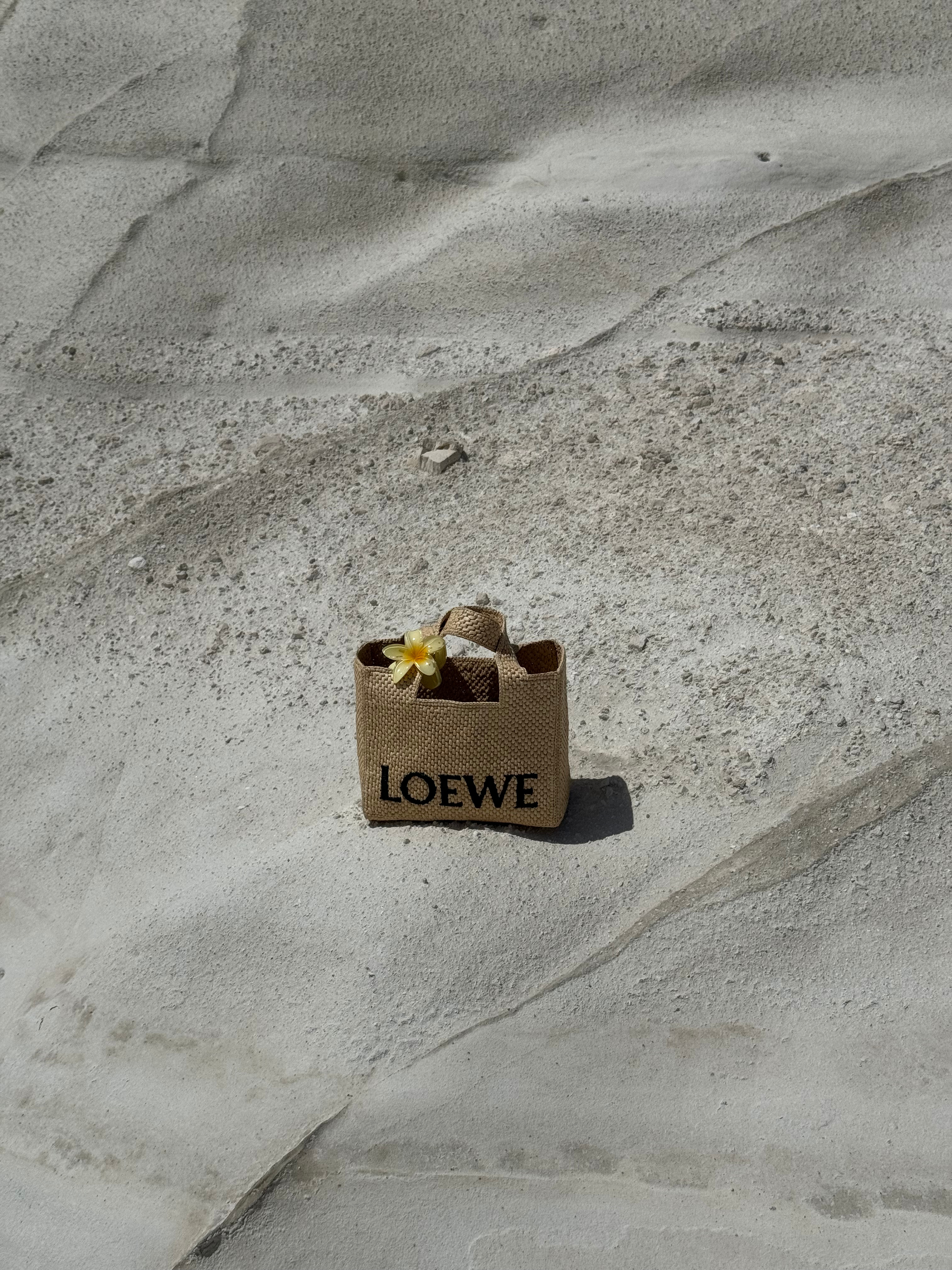 A small bag rests gently in the soft sand of the resort, ready for a day of seaside adventure and relaxation.