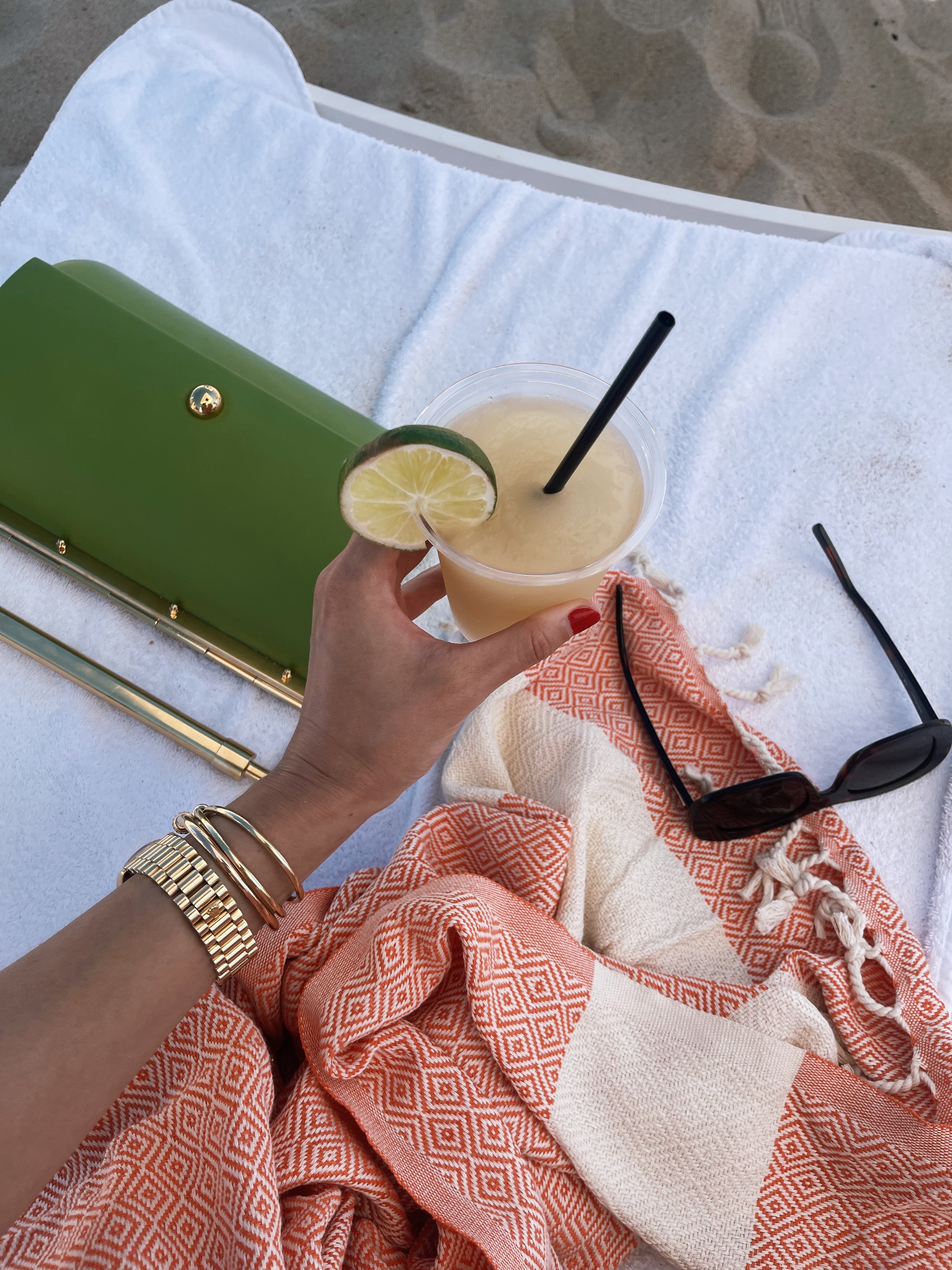 Natalie Suarez drinking a cocktail by the beach in the hamptons wearing sommer swim bikini