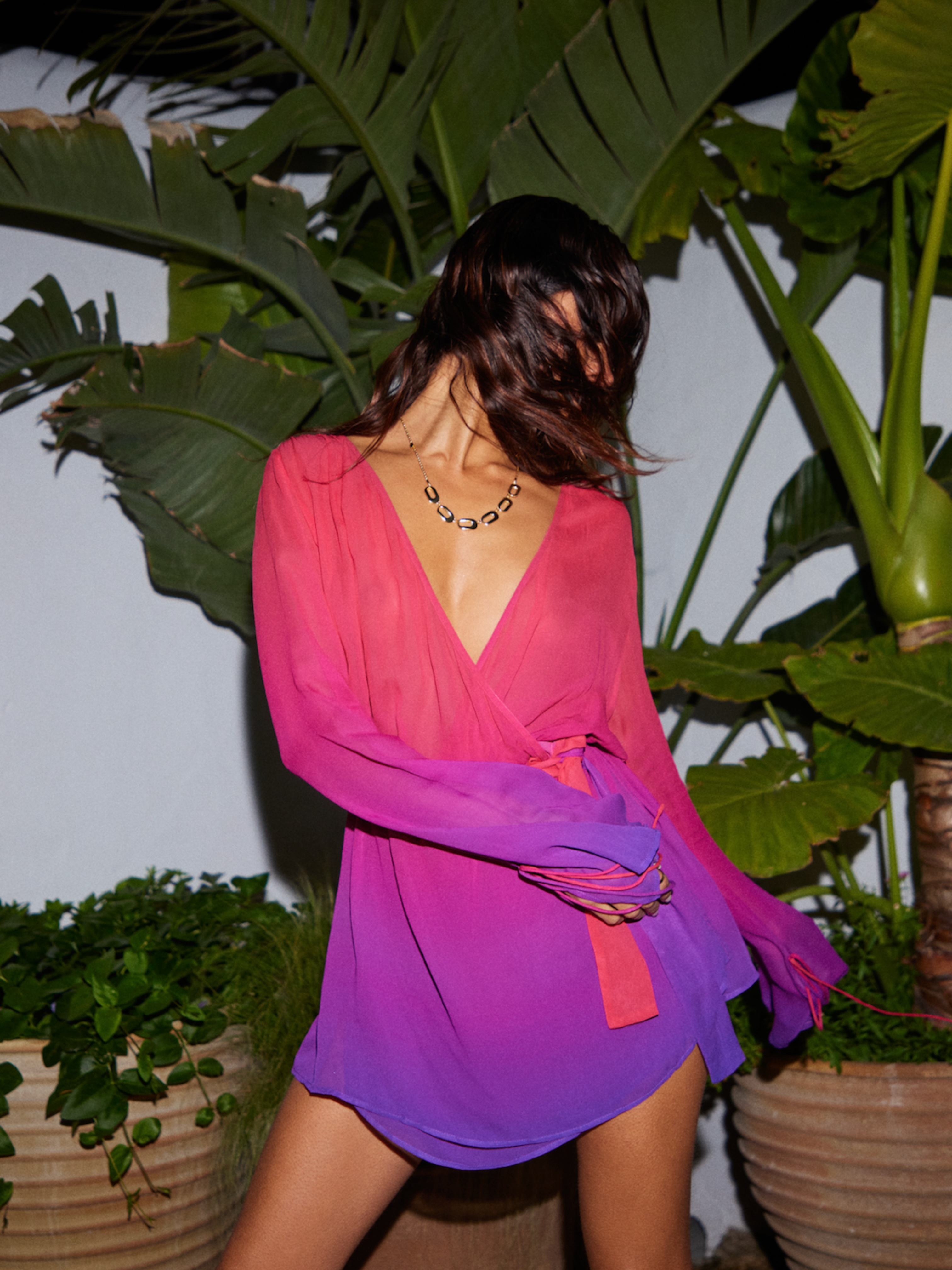 Stylishly draped in the Palma Wrap Dress from Sommer Resort SS24, featuring a sultry v-neckline and radiant magenta to opulent purple ombre print