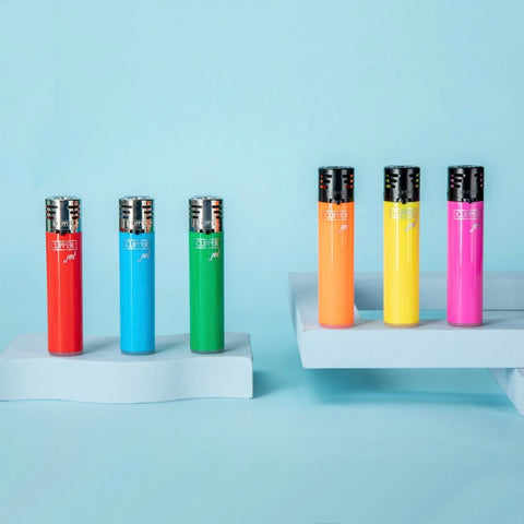 pale blue background featuring six different solid color Clipper lighters.  The lighters are red, blue, green, orange, yellow, and pink.  The lighters are positioned on two uneven-level, wavy-shaped platforms, three on each platform.  The colors are all bright pastels and the shapes featured in the image are asymmetrical.