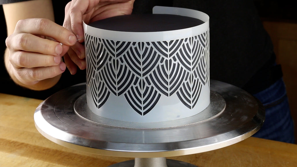 Wrap the stencil around the cake using pins to hold it in position