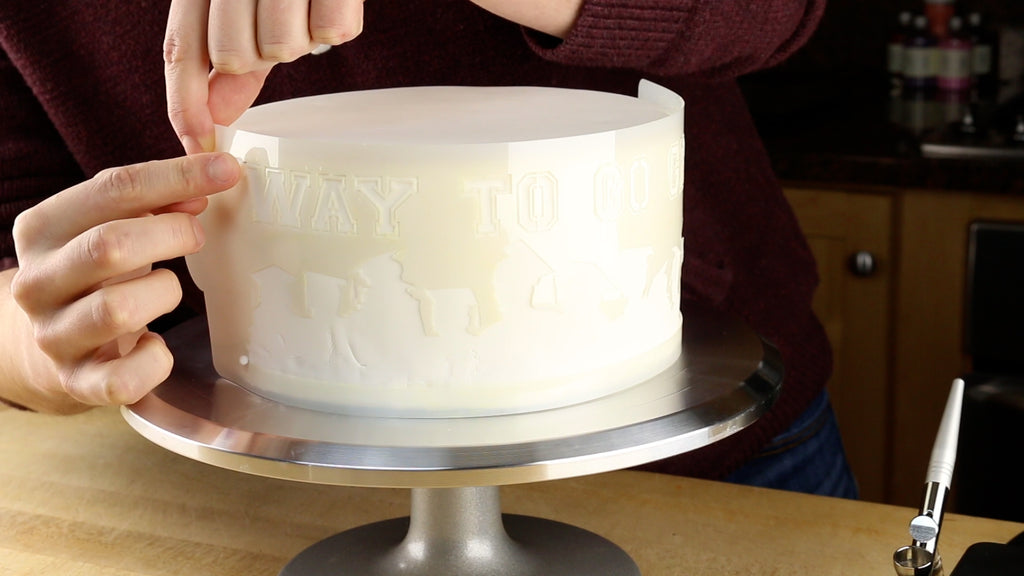 Fasten the stencil to the side of the cake using sewing pins