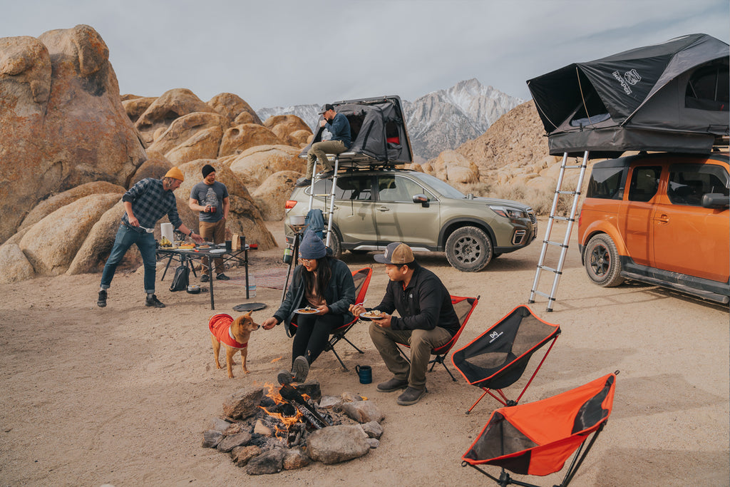 Campers eating breakfast around a fire in front of a Subaru Forester with Skycamp 3.0 Mini and a Honda Element with X-Cover 2.0