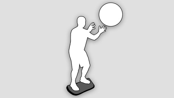silhouette of man catching a ball on stability board