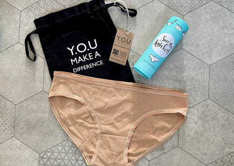 Y.O.U Underwear Organic Cotton Almond Bikini Bottoms are surrounded by the Save My Knickers blue tube and our packaging