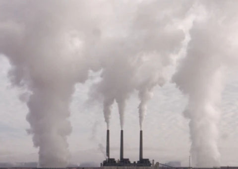 A factory with fumes coming from chimneys 
