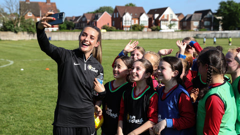 The Lionesses' Ella Toone taking a selfie with young female footballers