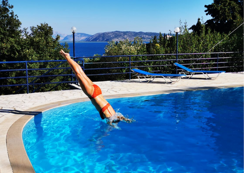 Sarah dives into a swimming pool wearing our red mara matching set