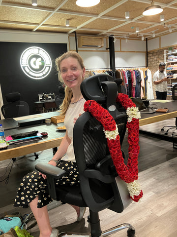 Sarah Jordan with a flower garland, meeting the manufacturing team at Connoisseur Fashions 