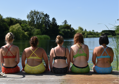 Women wear 5 different Mara colours sat in front of a lake
